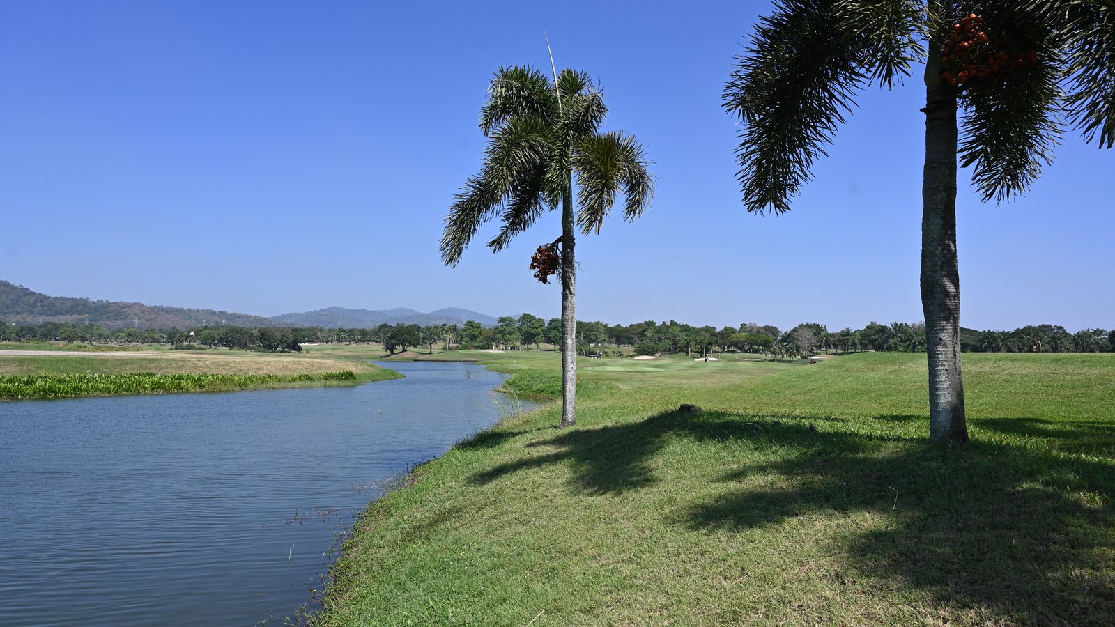 Golf course fairway beside a calm waterway